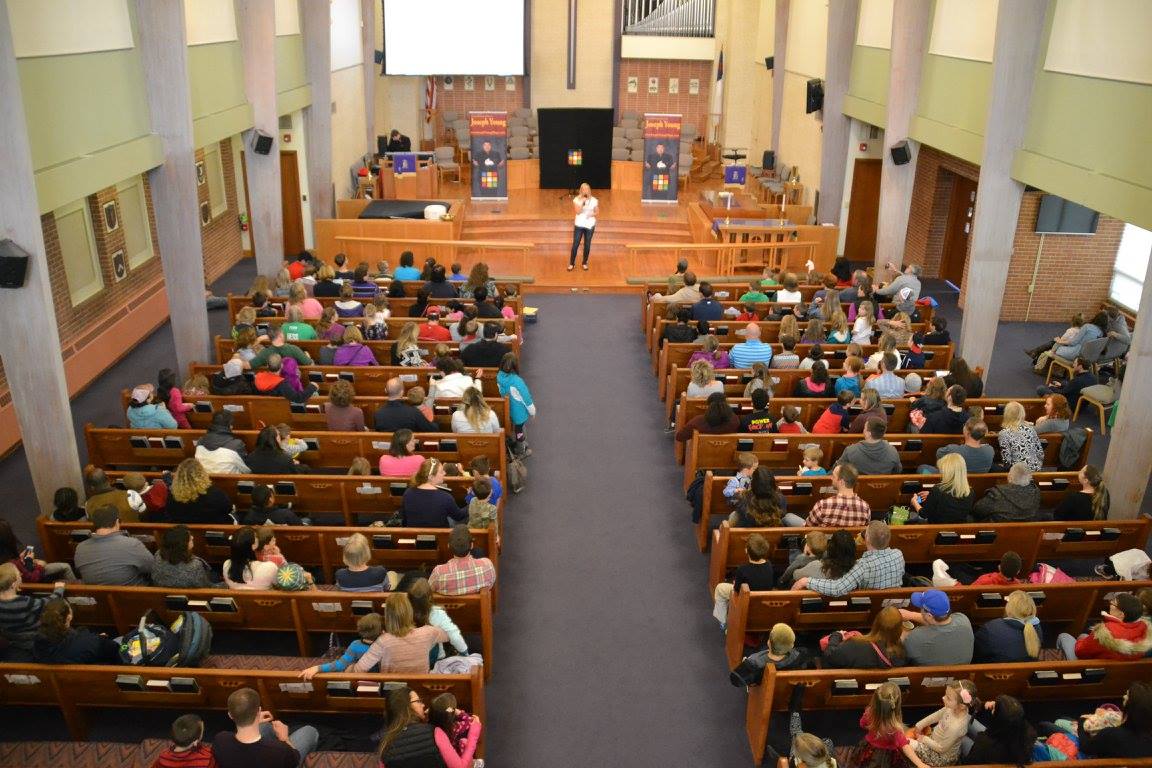 Person speaking in front of large audience at a church